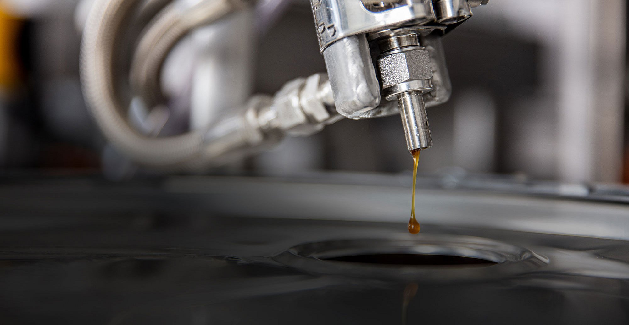 Detailansicht-Destillationsendprodukt Konzentriertes Produkt fließt aus der Destillationsanlage in Auffangbehälter